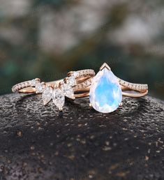 two engagement rings on top of each other, one with a blue stone and the other with diamonds