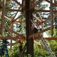 a man climbing up the side of a wooden structure