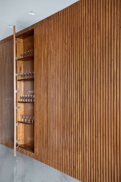 an empty room with wooden walls and shelves on the wall is filled with glassware