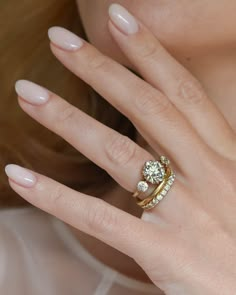 a close up of a woman's hand with a ring on her finger and an engagement ring