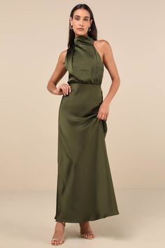 a woman in a long green dress with a halt neckline and side slits