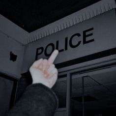 a hand pointing at the police sign above an apple store door that reads,'police '