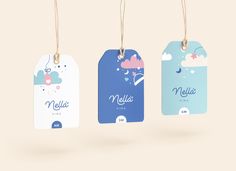 three tags hanging from strings with the name melia on them and clouds in the sky