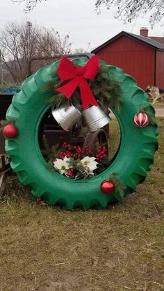 a christmas wreath made out of an old tire with bells on it and flowers in the center