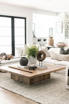 a living room filled with white furniture and lots of pillows on top of the couches