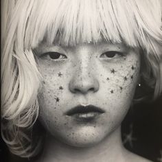 a black and white photo of a woman with freckles on her face