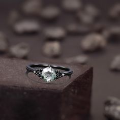 an engagement ring with a green stone in the center