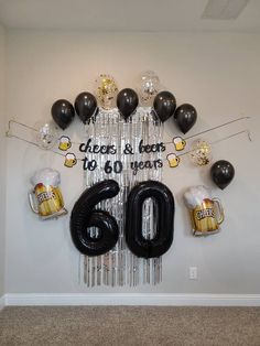 balloons and streamers are hanging from the wall in front of a sign that reads cheers & beers to 60 years