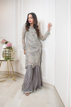 SKU: 1107 Price for Shirt, lining and Dhaka Pyjama A soft pure net with our signature embroidiery of floral net handwork, resham, tilla, crystals, kora, and sequence. Cutwork border used in this outfit gives a modern look to this outfit. Double layered Dhaka Pyjama is gives oomph to this outfit. Dupatta as is can be added. Shirt length 38. Model is wearing XS. Elegant Embellished Net Sharara, Sequin Organza Salwar Kameez For Eid, Eid Sequined Organza Salwar Kameez, Elegant Net Sharara With Mirror Work, Eid Organza Salwar Kameez With Sequins, Designer Net Sharara For Eid, Embellished Net Sharara For Festive Occasions, Festive Embellished Net Sharara, Embellished Net Dupatta For Eid