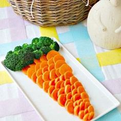 carrots and broccoli arranged on a white plate