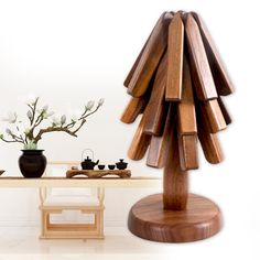 a wooden sculpture sitting on top of a table next to a vase filled with flowers