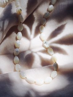 This long white mother of pearl pikake shell necklace evokes visions of Hawaii's flower leis and reflect Hawaii's natural abundance. This unique beauty is ready for you and your tropical escape.✦ DETAILS ✦✧ Name: Kēhau (keh-how) - dewdrop.✧ 38" Length.✧ White Mother of Pearl beads.✧ 14kt Gold Filled clasp and beads.✧ All Ke Aloha Jewelry pieces come packaged thoughtfully, beautifully, and ready for gift giving.✧ Unless otherwise noted in the listing description, all pieces are sold individually. Cheap White Mother Of Pearl Necklaces, White Shell Necklace With Natural Stones, Mother Of Pearl Necklace With Polished Beads For Gifts, Mother Of Pearl Necklace With Polished Beads As Gift, Pearl White Beaded Necklace In Mother Of Pearl, Elegant White Shell Necklace With Natural Stones, Delicate White Necklaces With Natural Stones, White Shell Beaded Necklaces In Mother Of Pearl, White Shell Jewelry With Natural Stones