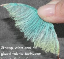 a hand holding a piece of yarn that is green and blue with words written below it