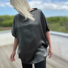 Elevate your wardrobe with our stunning lustrous grey satin top, designed in a loose-fit style. Fold the hem up over your hips or tucked into a pair of pants or a skirt. Whether it's a day at the office, a night out with friends, or a romantic date, this top adds an elegant touch to any occasion. Crafted from a luxurious heavyweight satin, it drapes beautifully, offering effortless sophistication with every movement Proudly made in Izmir Turkey by Kopenhag Studio Good to know The model is 5'6" and wears a small Ecovero from Lenzing is a sustainable vegan silk made from responsibly sourced wood pulp. Handwash inside out or wash inside out on cold Sleek Tops With Sheen For Night Out, Sleek Evening Tops With Sheen, Sleek Sheen Tops For Evening, Chic Gray Evening Tops, Chic Oversized Silk Top, Oversized Silk Tops, Chic Satin Tops With Sheen, Shift Dress Black, Satin Top