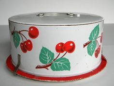 an old tin can with cherries painted on the side and red trim around the bottom