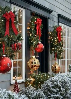 christmas decorations are hanging on the outside of a building in front of a window with red and gold baubes