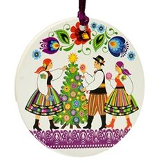 an ornament with two people standing next to a christmas tree and colorful flowers