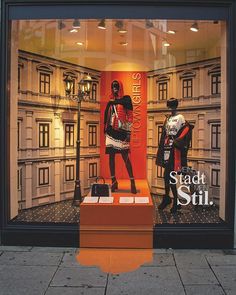 two mannequins in front of a store window with the words straddling still