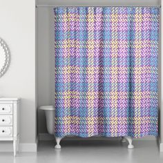 a bathroom with a sink, mirror and shower curtain in purple and blue plaid pattern