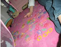 a child is playing on a pink rug