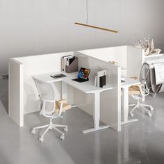 an office desk with two chairs and a laptop on it in front of a white wall