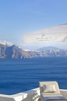 an outdoor lounge chair and umbrella overlooking the ocean