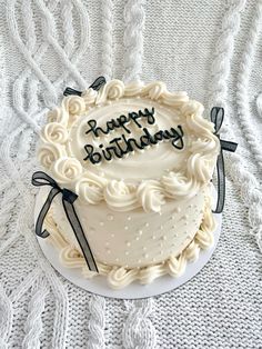 a birthday cake with the words happy birthday on it sitting on a white tablecloth