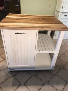 a kitchen island made out of wood and white cabinets