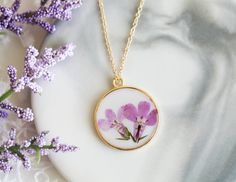 "New design with dried pressed real flower in white background. Simple, clean, elegant, feel calm and peaceful in the heart. You can see the natural pattern of the flower. Every flower is unique, and you are unique. It's a good gift for your loved one or treat yourself. Gold plated bezel and stainless steel chain. High quality UV resin, odor free. Pendant diameter: 1 inch/25mm Chain length: 16\"+2\" extender(40cm+5cm) Come with craft gift box. Please note that there will be slight variations in Nature-inspired White Birth Flower Necklace, White Flower Pendant Necklace With Pressed Flowers, White Nature-inspired Necklace With Pressed Flowers, Nature-inspired White Necklace With Pressed Flowers, Round Floral Print Jewelry Gift, Round Floral Print Jewelry For Gift, Floral Print Round Jewelry Gift, Floral Print Round Jewelry For Gifts, Minimalist Pressed Flower Necklace For Mom