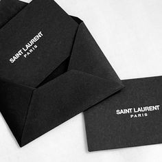 two black envelopes sitting on top of each other with the same logo printed on them