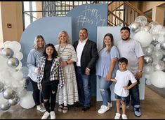 a group of people standing next to each other in front of a sign that says happy father's day