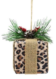 a leopard print ornament hanging from a rope with pine cones and berries on it