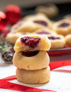 three cookies stacked on top of each other with raspberry filling in the middle