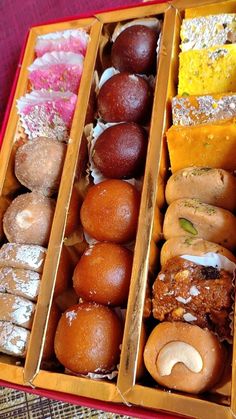 three boxes filled with different types of doughnuts on top of a red table