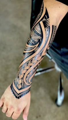 a man's arm with an intricate tattoo design on the arm and wrist area