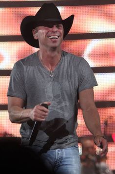 a man wearing a cowboy hat and holding a microphone