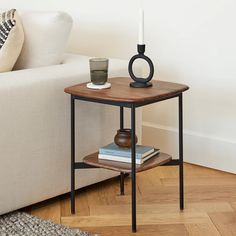 a living room with a couch, table and coffee cup on the end table in front of it