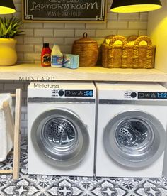 two washers sitting next to each other in front of a shelf with towels on it