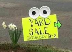 a yard sale sign with googly eyes on it