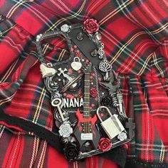 a red and black plaid shirt with an electric guitar on the chest, some keys attached to it