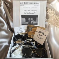 the bridesmaid gift box is packed with sunglasses, cards and other personal items