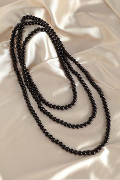 This sumptuous piece of jewelry features a retro-elegant yet slightly modern style that complements the lavish garments, reminiscent of the roaring 1920s. Features: Lustrous imitation pearls Minimalist design 69 inch / 175cm long Pearl size: 8mm in diameter Elegant Black Beaded Pearl Necklace, Elegant Long Pearl Chain Necklace For Party, Elegant Party Necklace With 108 Beads, Elegant Necklace With 108 Beads For Party, Elegant Multi-strand Beaded Long Necklace, Elegant Black Multi-strand Long Necklace, Elegant Black Beaded Necklaces, Elegant Multi-strand Beaded Necklaces For Formal Occasions, Elegant Black Beaded Necklaces For Evening