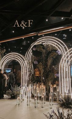 people are standing in front of a display with candles and flowers on it at an event