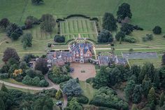 an aerial view of a large mansion surrounded by trees