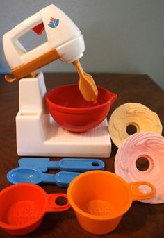 an electric mixer and bowls on a wooden table