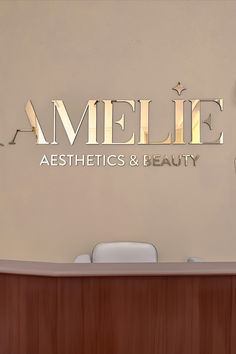 the name amelie aesthetics and beauty is spelled in gold letters above a wooden desk