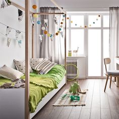 a child's bedroom with white walls and wood flooring is decorated in green