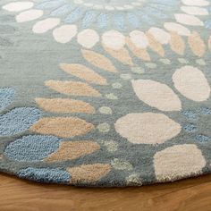 a blue rug with flowers on it sitting on a wooden floor in front of a window