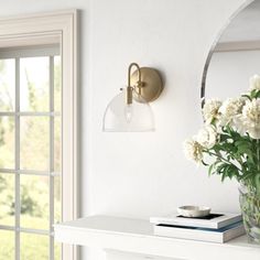 a vase filled with flowers sitting on top of a white table next to a mirror