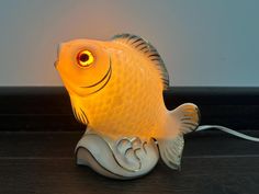 a yellow fish lamp sitting on top of a wooden table